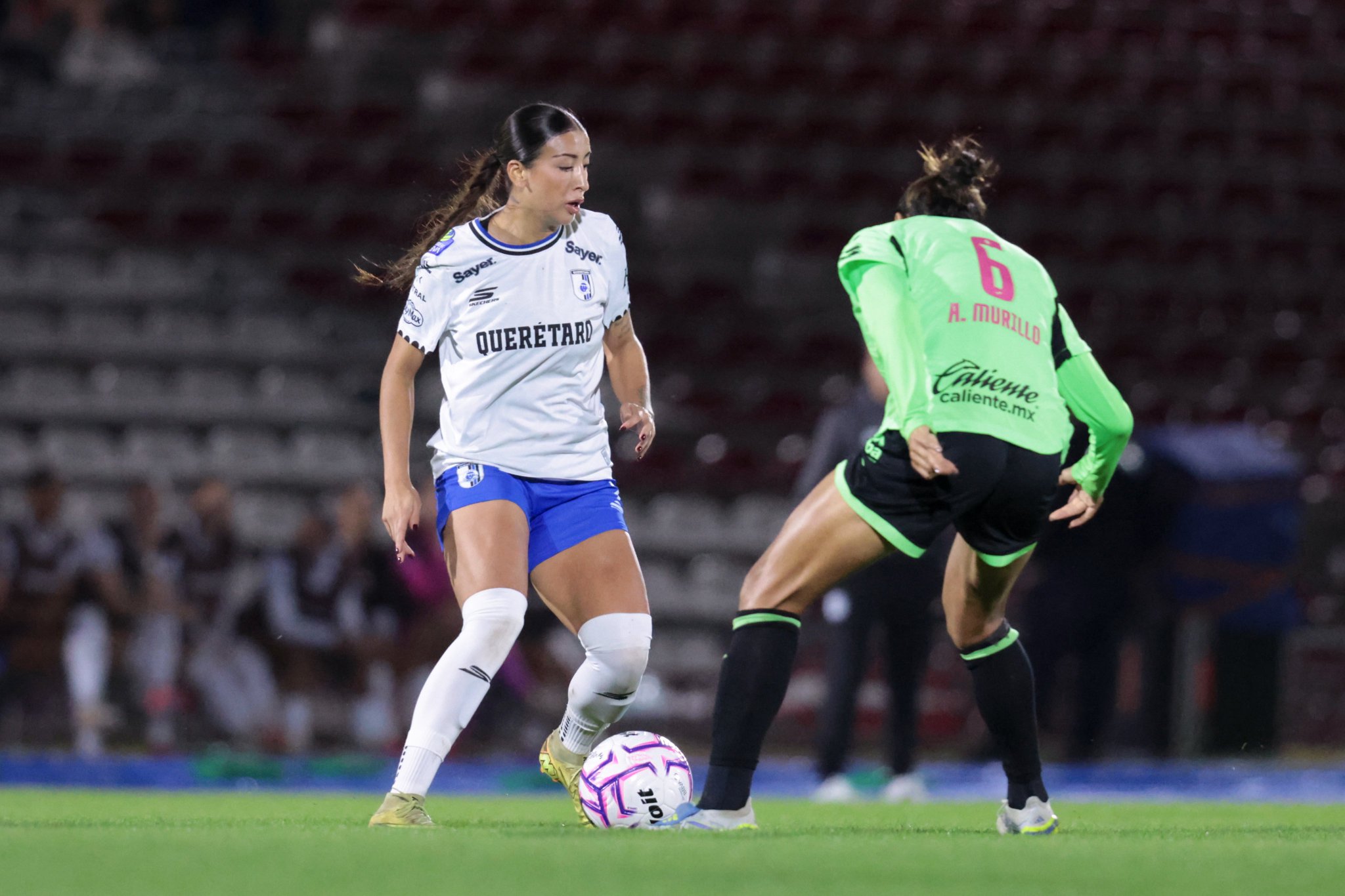 Jugadora de Querétaro Femenil conduce el balón ante una defensora de FC Juárez en el Estadio Olímpico Benito Juárez